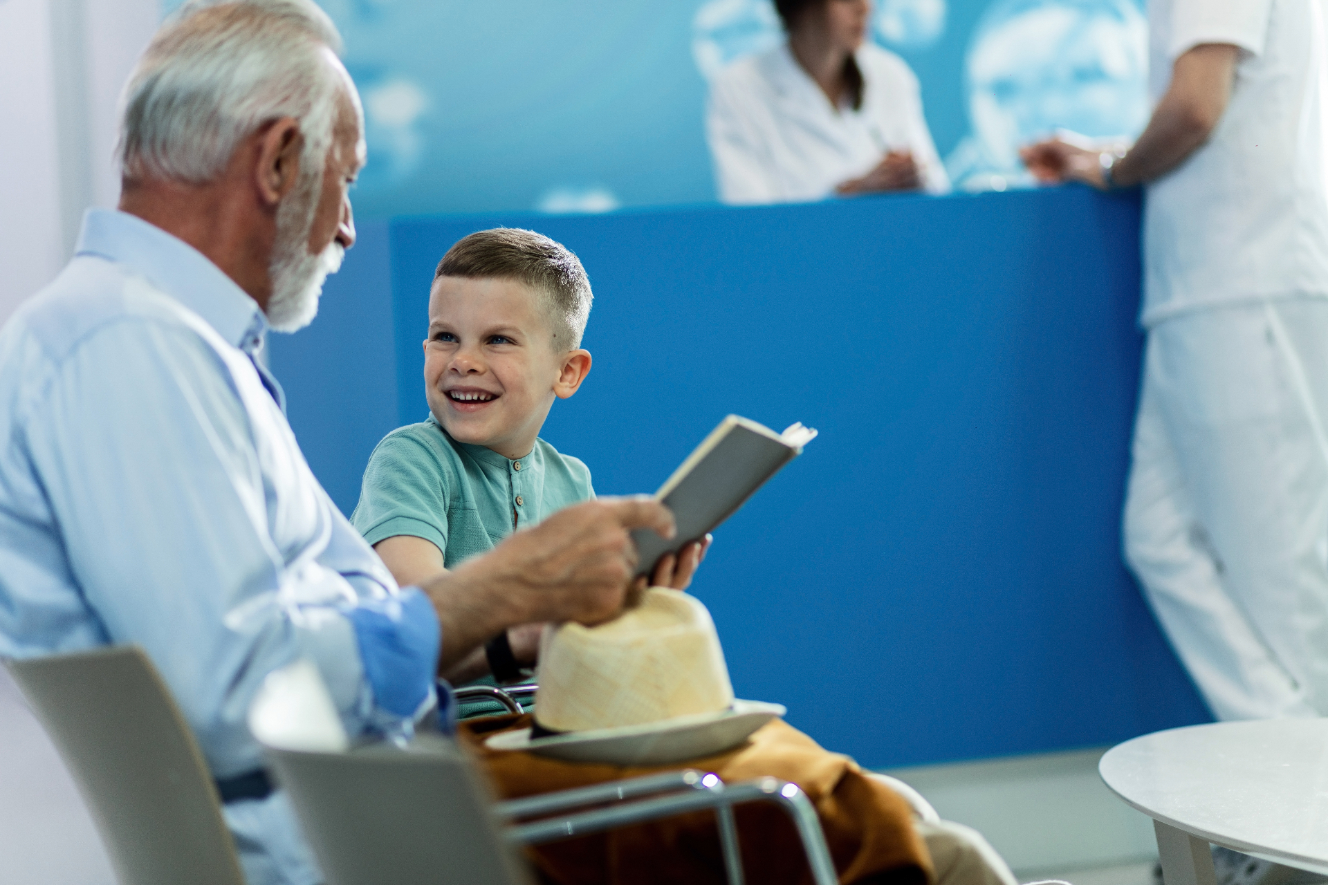 A caring clinician with a young patient and an older adult in a neurology clinic
